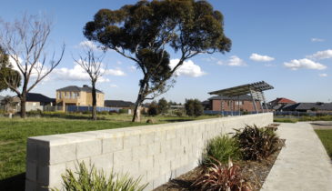 Exterior of open space with houses in the background and vegetation