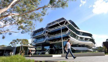 Exterior of Parkville campus with people walking and a multi-storey building in the background