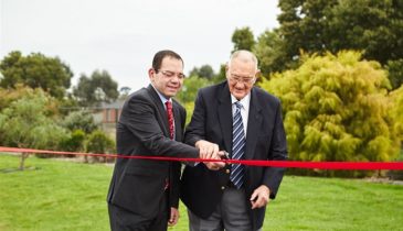City of Casey councillor Sam Aziz and developer Gordon Gill celebrate the start of works for for the Thompsons Road extension. They are cutting a red ribbon