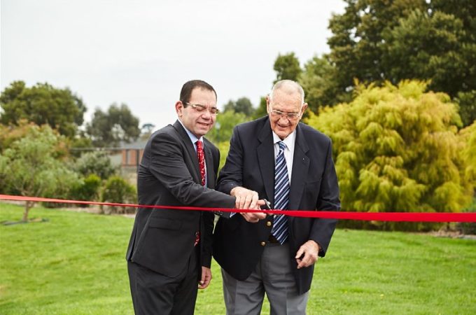 City of Casey councillor Sam Aziz and developer Gordon Gill celebrate the start of works for for the Thompsons Road extension. They are cutting a red ribbon