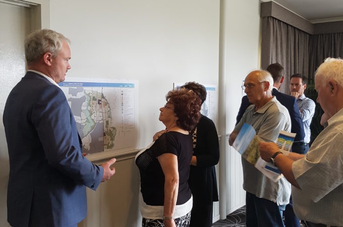 Community engagement in Sunbury with people discussing a map of the proposed plans