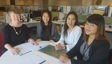 Four women seated at a table with a map in front