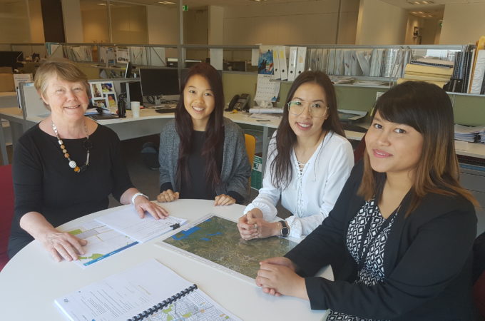 Four women seated at a table with a map in front