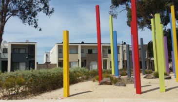 Playground wooden sculptures with medium density townhouses in the background